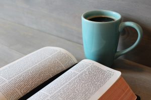 Aufgeschlagene Bibel und Tasse Kaffee